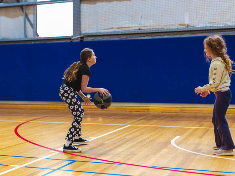 Two girls playing basketball at Wilandra Rise Primary OSHC